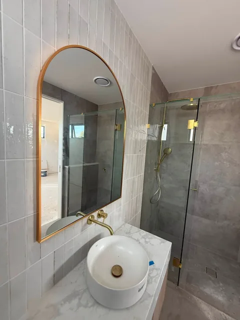 Arched brass mirror and shower screens