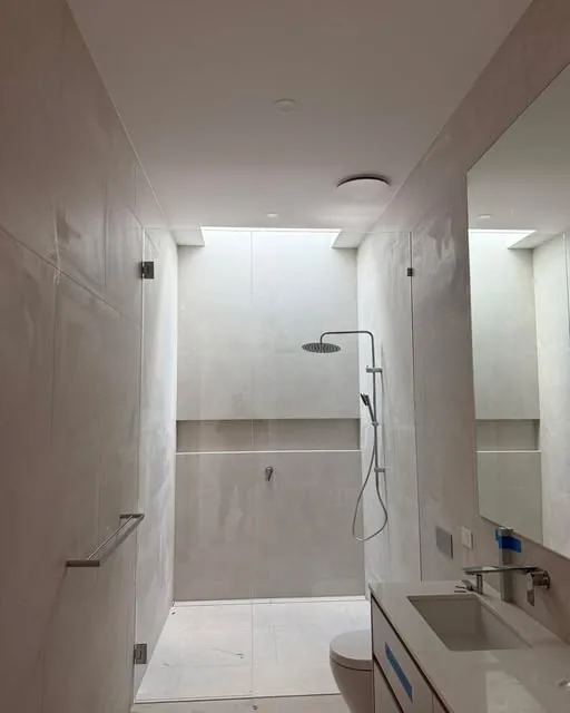 Frameless shower facing a garden atrium