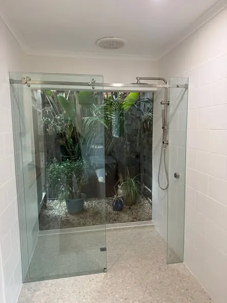 Frameless shower facing a garden atrium