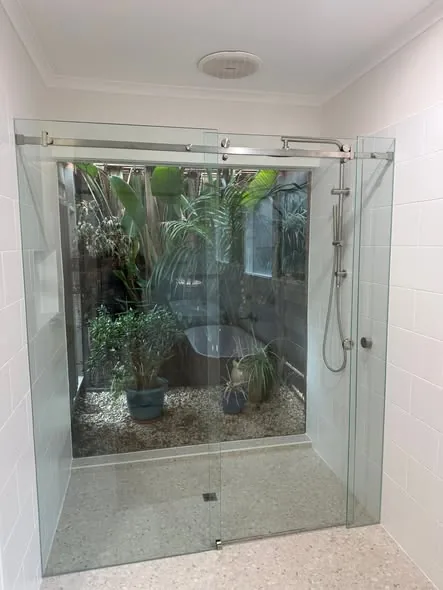 Frameless shower facing a garden atrium